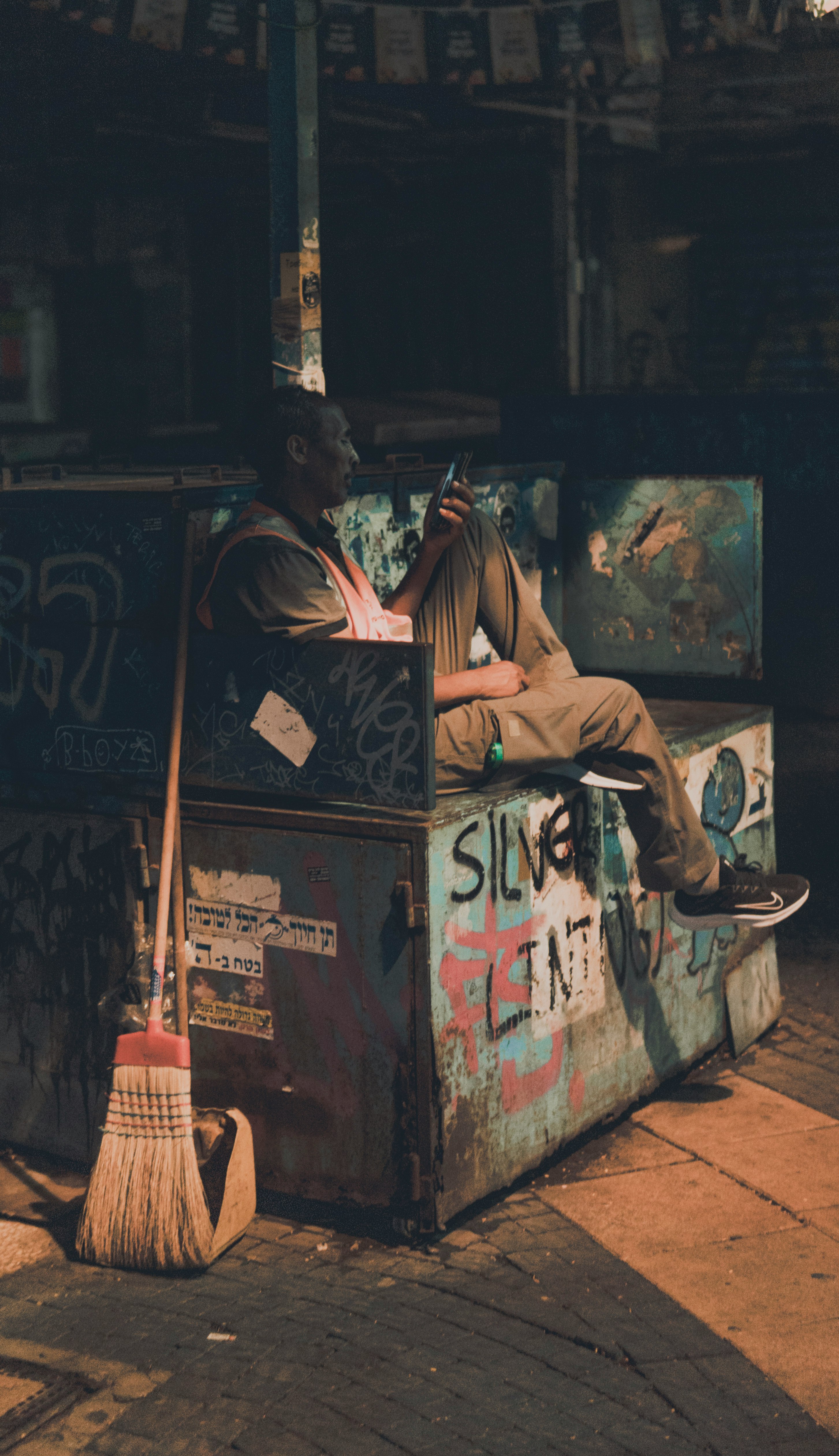 man in brown jacket sitting on chair reading book